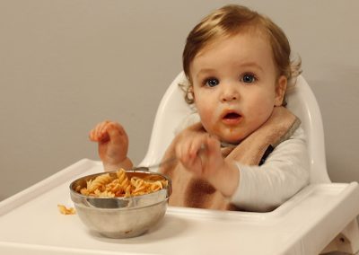 baby-eating-pasta-in-high-chair