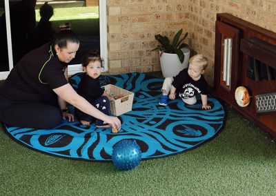 educator-and-toddlers-playing-on-rug